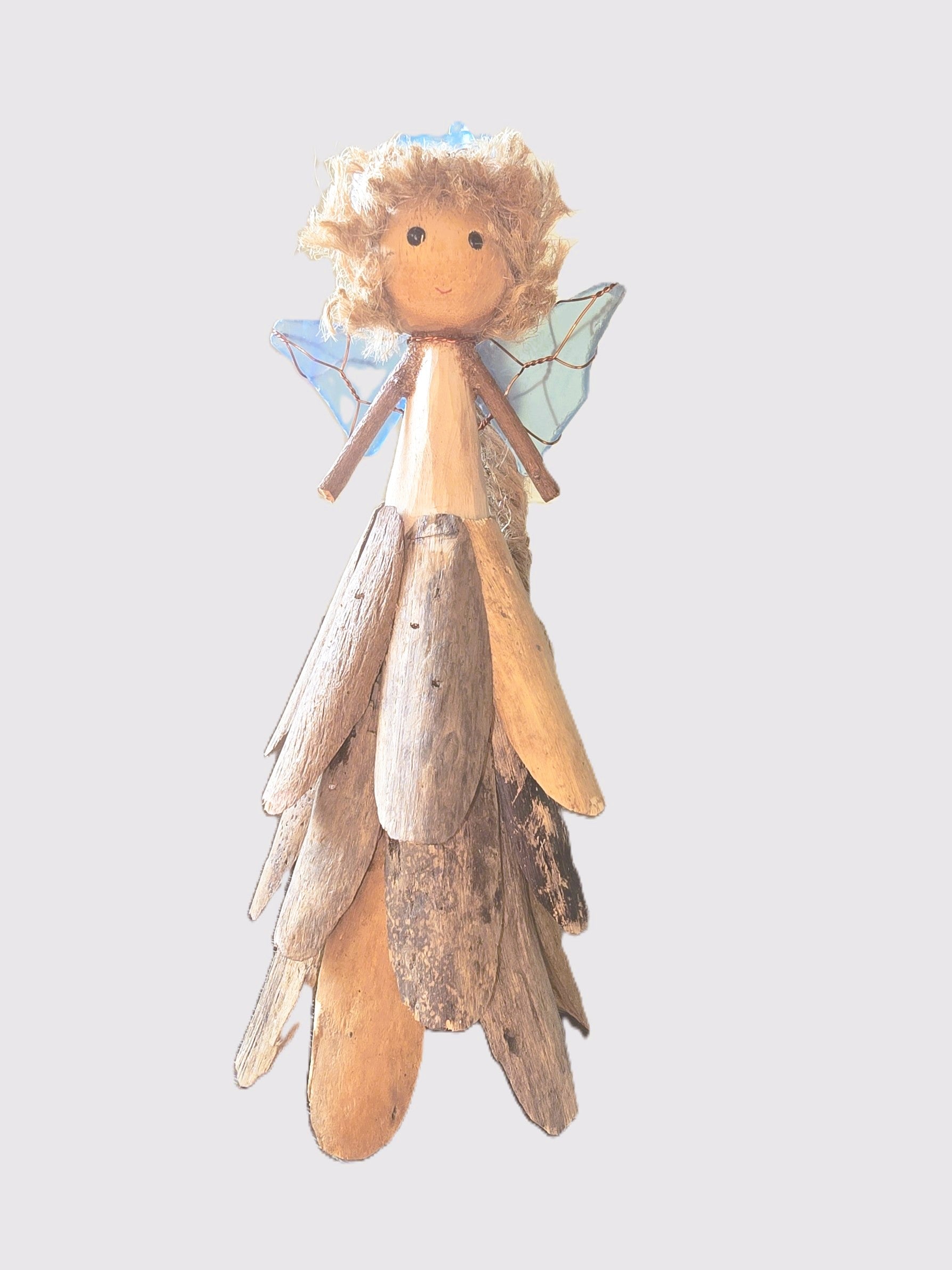 Wooden fairy figurine with driftwood wings on a light gray background